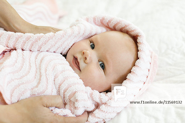 Portrait of baby boy (12-17 months) in pink blanket