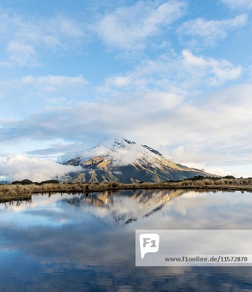 Reflection in Pouakai Tarn  stratovolcano Mount Taranaki or Mount Egmont with cloud  Egmont National Park  Taranaki  New Zealand  Oceania