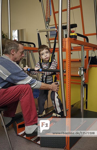 Disabled child  rehabilitation in gait trainer as part of physiotherapy  Germany  Europe