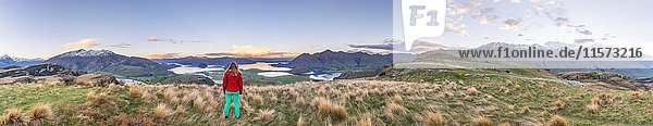 Wanderer mit Blick auf den Lake Wanaka und die Berge  Rocky Peak  Glendhu Bay  Otago  Southland  Neuseeland  Ozeanien