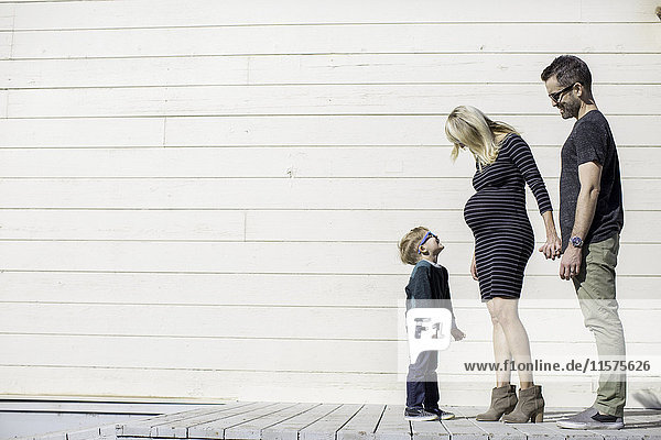 Eltern und Junge neben einem Holzgebäude