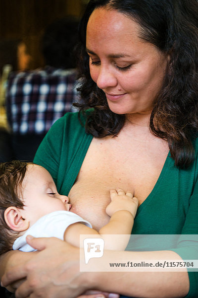 Reife Frau stillt Baby Sohn im Café