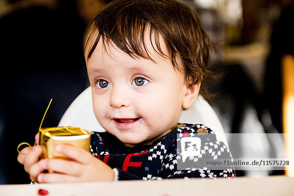 Kleiner Junge hält goldenes Weihnachtsgeschenk