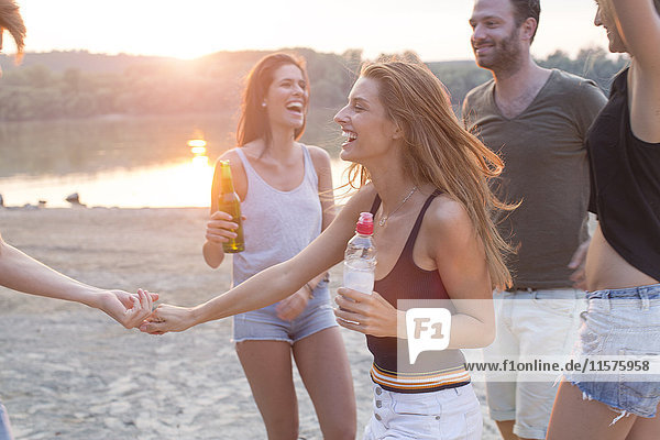 Gruppe von Freunden trinkt  genießt Strandparty