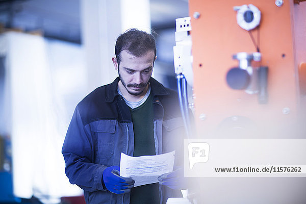 Ingenieur der das Bedienfeld für den Papierkram hält