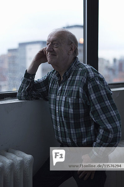 Mann schaut lächelnd aus dem Fenster  Manhattan  New York  USA