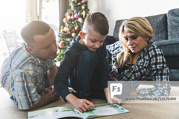 Mother and father listening to son read book