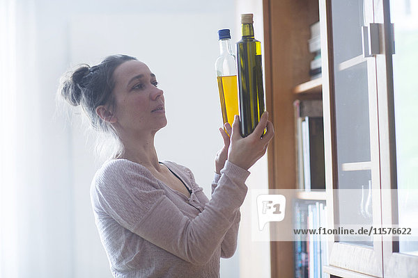 Woman comparing bottles of oil