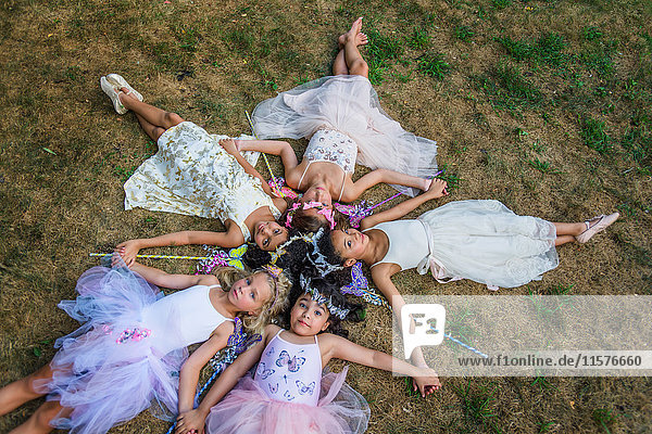 Gruppe junger Mädchen  als Feen verkleidet  im Kreis liegend  Köpfe zusammen
