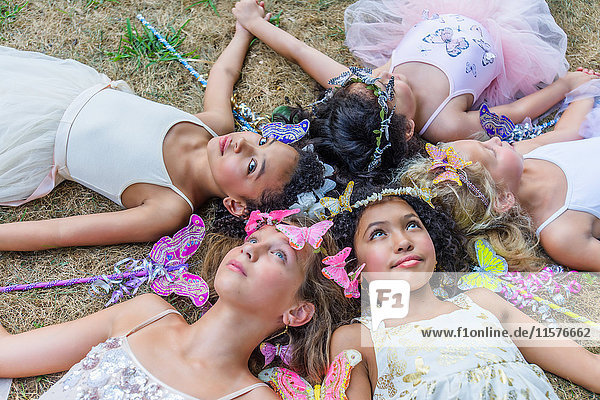 Gruppe junger Mädchen  als Feen verkleidet  im Kreis liegend  Köpfe zusammen