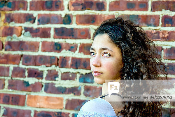 Portrait of teenage girl leaning against wall