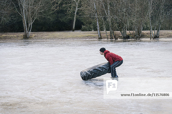Frau dreht Reifen auf gefrorenem See um