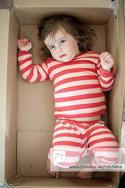 Baby girl play lying in box