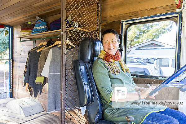 Reife Hippie-Frau auf dem Fahrersitz eines Wohnmobils