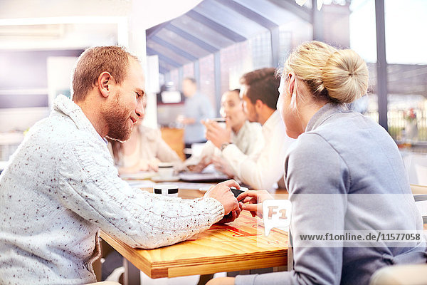 Businesswoman and man using smartphone touchscreen at office meeting
