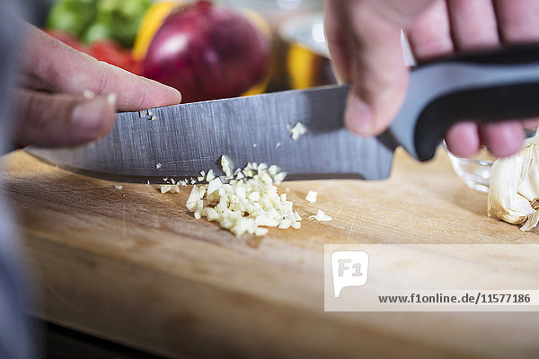 Chef chopping fresh garlic  close-up