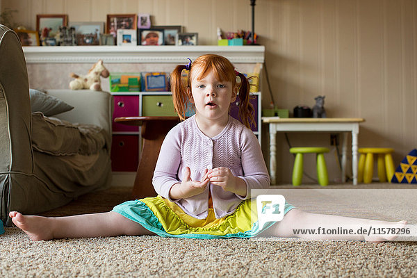 Bildnis eines jungen Mädchens mit roten Haaren  auf Teppich sitzend  Beine ausgestreckt