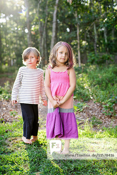 Porträt eines Jungen und eines Mädchens im Garten stehend