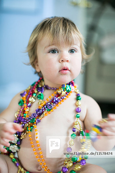 Weibliches Kleinkind probiert Perlenketten in der Küche an