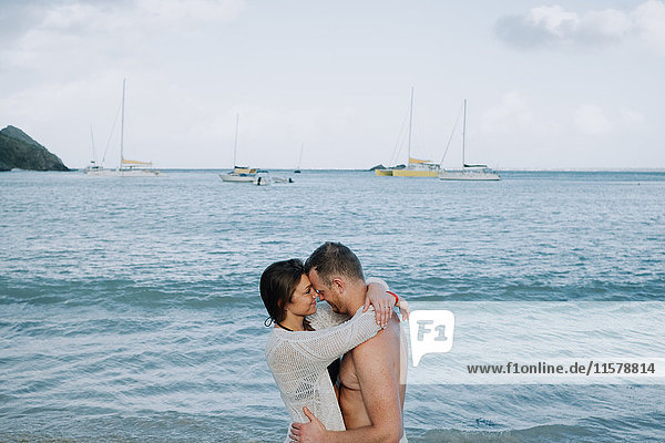 Couple standing by sea  hugging  face to face  Saint Martin  Caribbean