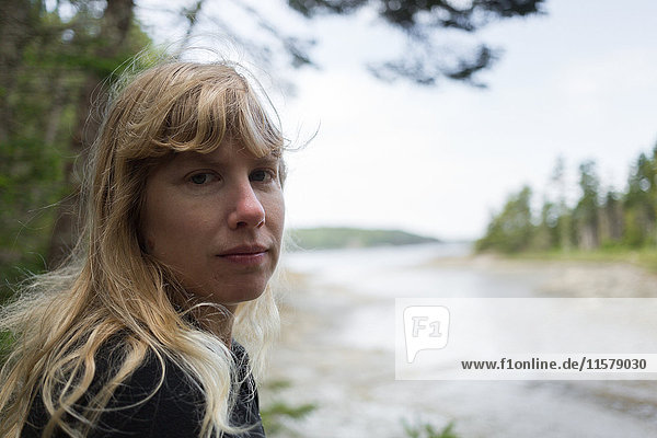 Porträt einer Frau  die an der Küste von Maine  USA  über ihre Schulter schaut