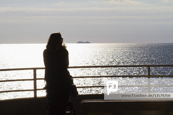 Frankreich  Nordwestfrankreich  Saint-Michel-Chefkoch  Tharon-Plage  junge Frau von hinten gesehen  Blick aufs Meer