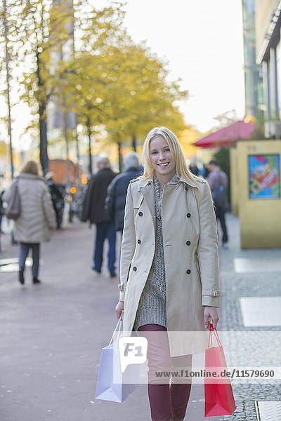 Hübsche blonde Frau mit Einkaufstaschen in der Innenstadt.
