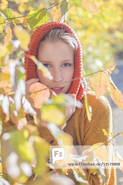 Porträt einer hübschen blonden Frau im Park im Herbst mit Blättern