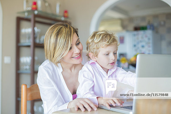 Mother and son with laptop at home