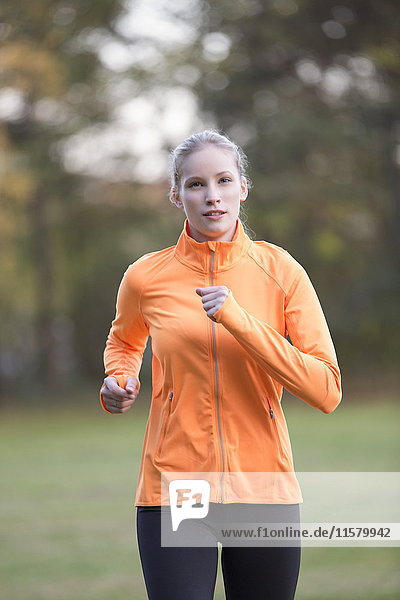 Hübsche blonde Frau beim Joggen im Park.