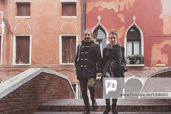 Ehepaar fährt Kanalbrücke hinunter  Venedig  Italien