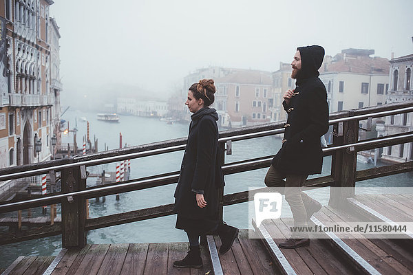 Ehepaar bewegt sich treppabwärts über einen nebligen Kanal  Venedig  Italien