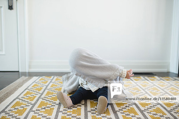 Kleines Mädchen versteckt sich unter einer Decke