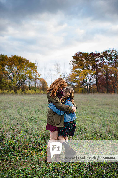 Mother and daughter hugging in meadow  Lakefield  Ontario  Canada