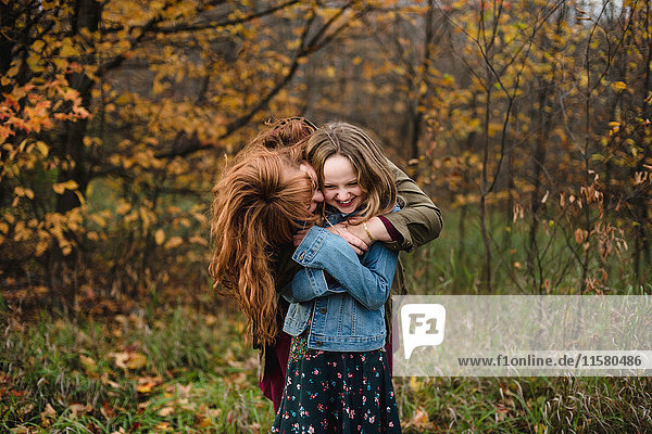 Mother and daughter hugging in wooded area  Lakefield  Ontario  Canada