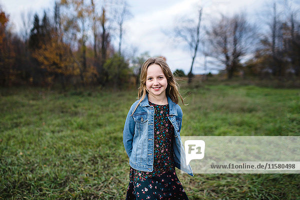 Young girl smiling in field in denim jacket  Lakefield  Ontario  Canada