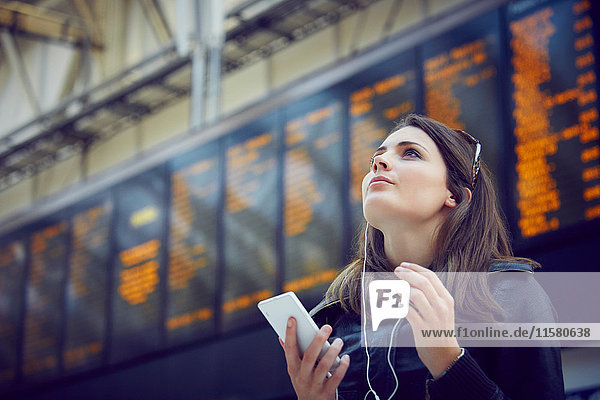 Woman looking at departure information  London  UK
