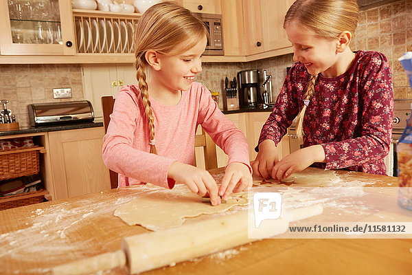 Two girls baking together at kitchen table