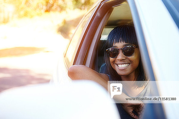 Porträt einer jungen Frau  die aus dem Autofenster schaut