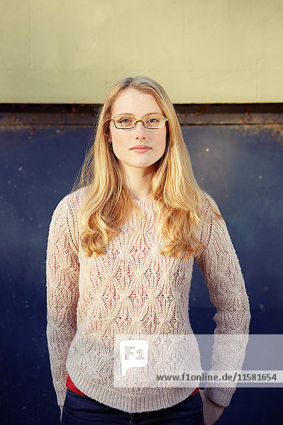 Porträt einer jungen Frau im Freien  lange blonde Haare und Brille
