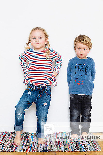 Portrait of young girl and boy against white background