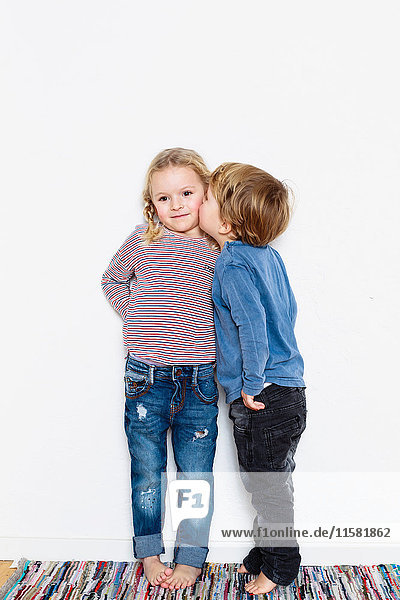 Young boy kissing young girl on cheek