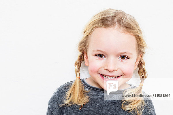 Porträt eines jungen Mädchens  lächelnd  vor weißem Hintergrund