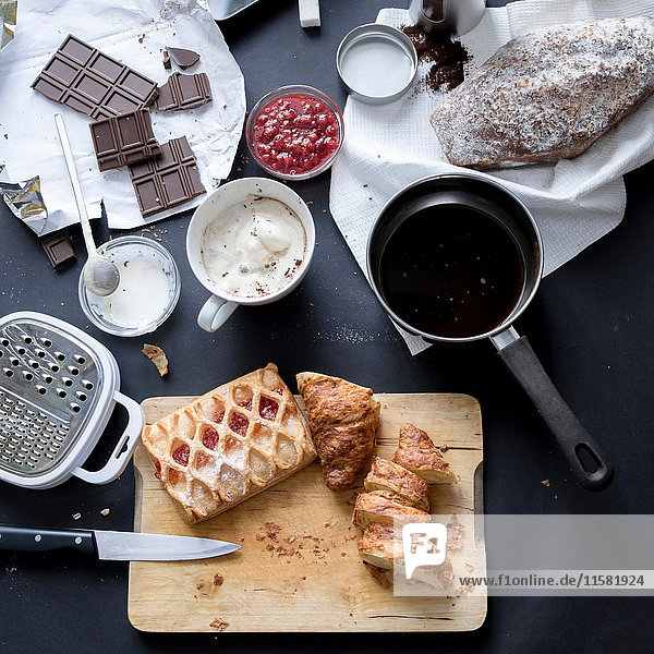 Draufsicht auf Apfelstrudel, Schokolade, Kuchen und Zutaten auf dem Küchentisch