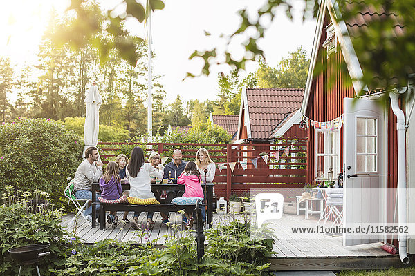 Glückliche Familie und Freunde beim Essen auf der Garten-Mittagsparty im Hinterhof