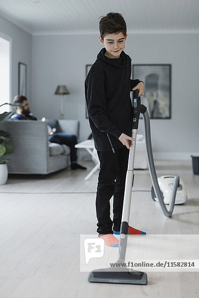 Boy Reinigung Boden mit Staubsauger zu Hause