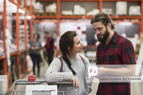 Couple using smart phone in hardware store