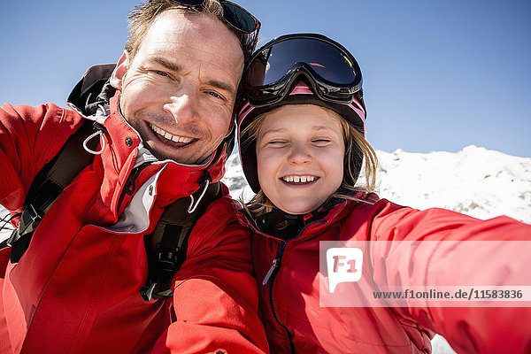 Portrait of cheerful father and daughter in warm clothing