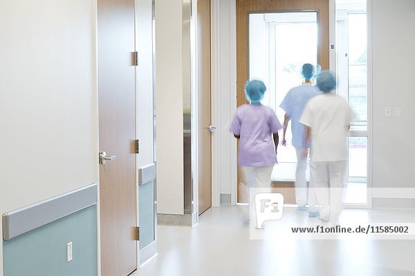 Medical staff walking down hospital corridor.