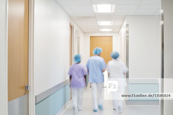 Medizinisches Personal geht einen Krankenhausflur entlang.